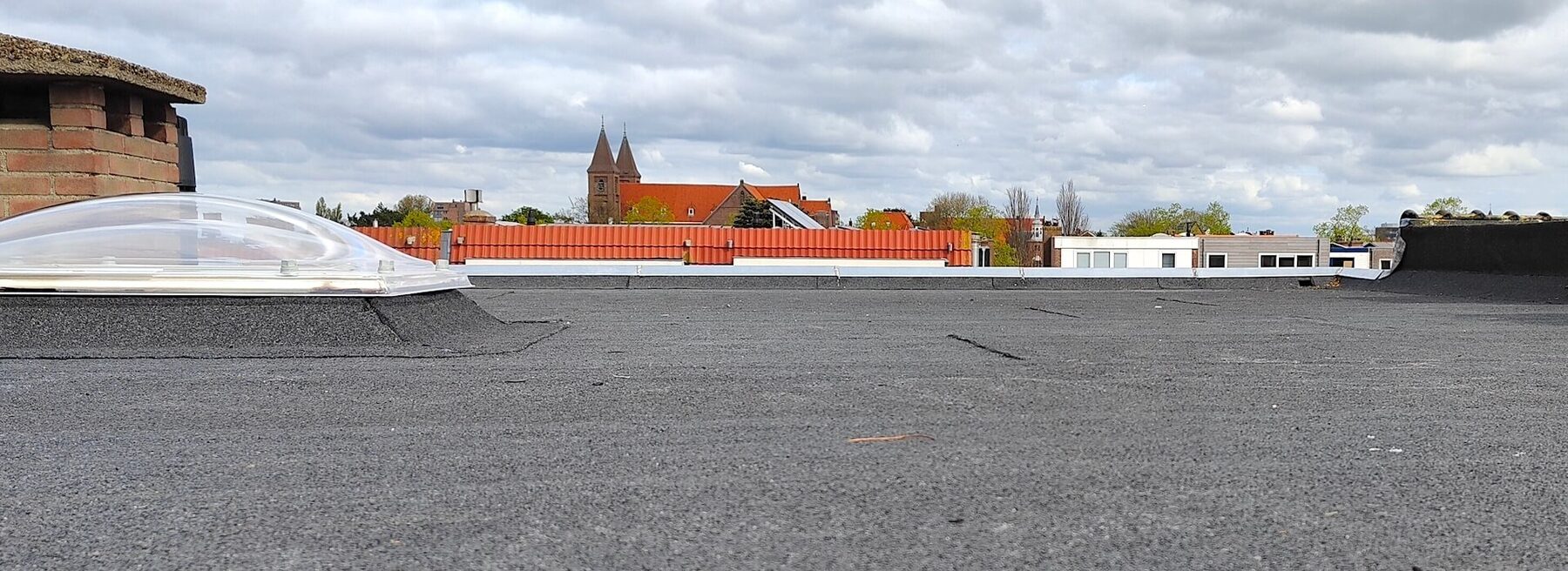 Plat dak met bitumineuze dakbedekking en lichtkoepels